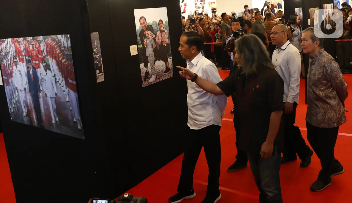 Presiden Joko Widodo atau Jokowi melihat pameran foto 'Membangun Indonesia'  di Jakarta, Selasa (12/11/2019). Pameran foto Membangun Indonesia itu menampilkan sejumlah capaian kinerja pemerintahan Presiden Joko-Widodo dan Wakil Presiden Jusuf Kalla. (Liputan6.com/Angga Yuniar)