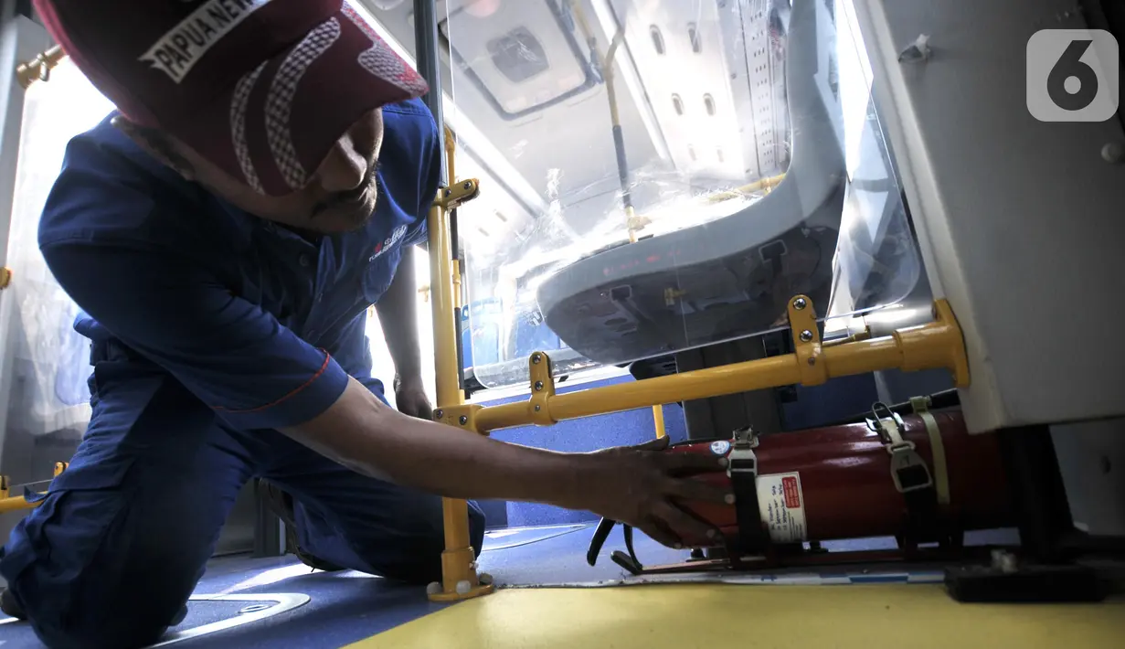 Teknisi menunjukkan alat pemadam kebakaran yang berada di bawah kursi penumpang bus Transjakarta Zhong Tong di Depo PPD F Klender, Jakarta, Rabu (30/10/2019). (merdeka.com/Iqbal S. Nugroho)