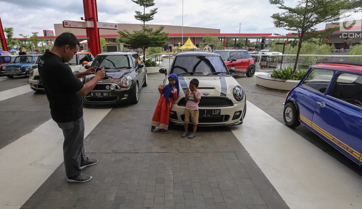 Pengunjung foto di samping mobil Mini klasik pada Indonesia Mini Day 2018 di QBig BSD, Tangerang, Sabtu (15/12). Kegiatan tahunan dari berbagai komunitas ditujukan untuk mempererat silaturahmi. (Liputan6.com/Fery Pradolo)