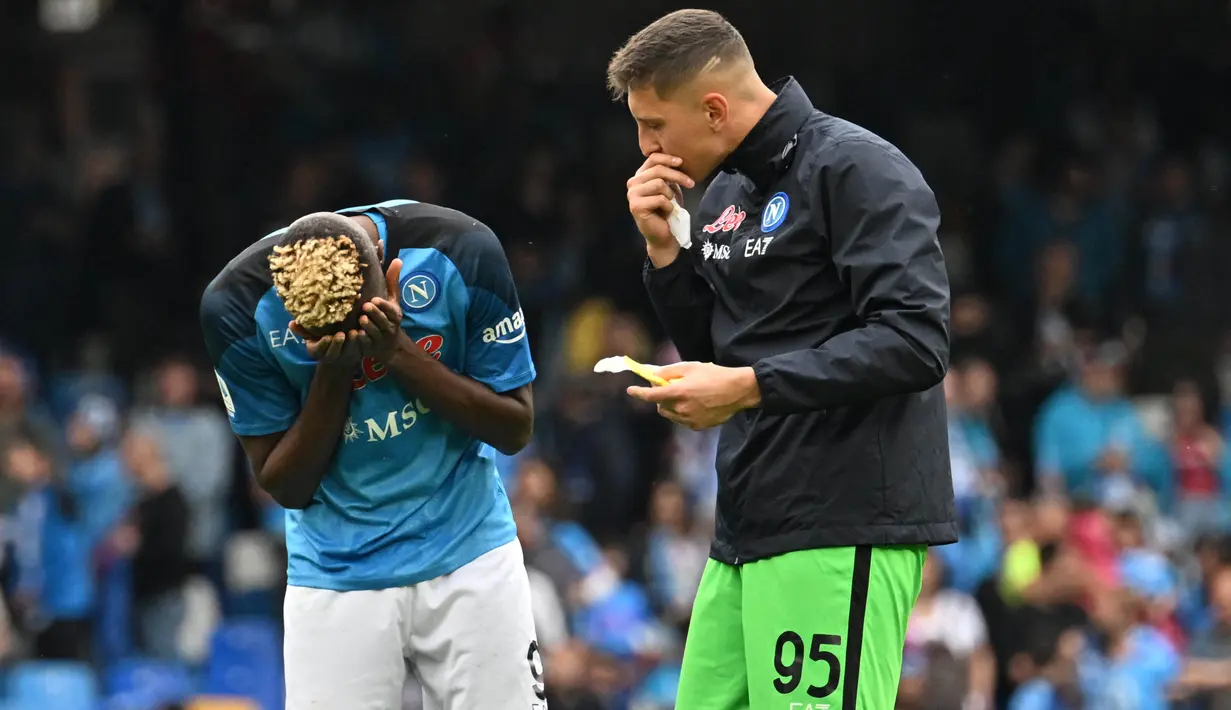 Penjaga gawang Napoli, Pierluigi Gollini (kanan), juga memberikan semangat kepada Victor Osimhen yang terlihat terpukul dengan hasil imbang 1-1 dalam pertandingan melawan Salernitana. Napoli yang sebenarnya sudah dimudahkan dalam meraih gelar juara setelah Inter Milan mengalahkan Lazio beberapa jam sebelumnya, kini harus bersabar dalam meraih gelar juara Serie A musim ini. (AFP/Filippo Monteforte)