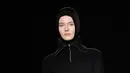 Model berjalan mengenakan hijab modern dan busana koleksi terbaru merek legendaris Paris, Lanvin di Paris Fashion Week Fall/Winter 2018/2019, Rabu (28/2). Hijab itu menyerupai hijab instan atau biasa disebut ciput ninja di Indonesia. (Patrick KOVARIK/AFP)