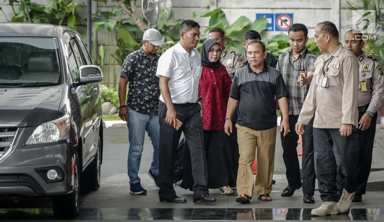 Asisten III Pemprov Jambi Syaifuddin (tengah), Anggota DPRD Jambi Nurhayati (belakang) dikawal petugas memasuki Gedung KPK, Jakarta, Rabu (29/11). Untuk di Jambi, tim bidang penindakan KPK mengamankan 7 orang. (Liputan6.com/Faizal Fanani)