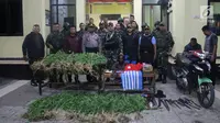 Yonif Raider 756/WMS menyerahkan pelaku pengedar ganja dan barang bukti ke Kapolres Jayawijaya AKBP Yan Reba (3/8). Mereka berhasil mengamankan Sajam, atribut/bendera Bintang Kejora, Miras dan 95, 20 gram ganja kering siap edar. (Liputan6.com/HO/Dispenad)