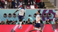 Winger Inggris Bukayo Saka (kiri) merayakan dengan rekannya Declan Rice setelah mencetak gol ke gawang Iran pada pertandingan Grup B Piala Dunia Qatar 2022 di&nbsp; Khalifa International Stadium, Senin, 21 November 2022. (Giuseppe CACACE/AFP)
