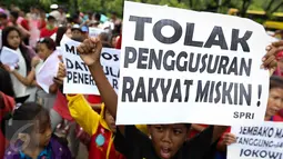 Seorang anak meneriakkan tuntutan sambil memegang poster saat menggelar unjuk rasa di depan Balai Kota DKI Jakarta, Kamis (3/11). Peserta aksi menolak penggusuran terhadap rakyat miskin dan menuntut penurunan harga sembako. (Liputan6.com/Faizal Fanani)