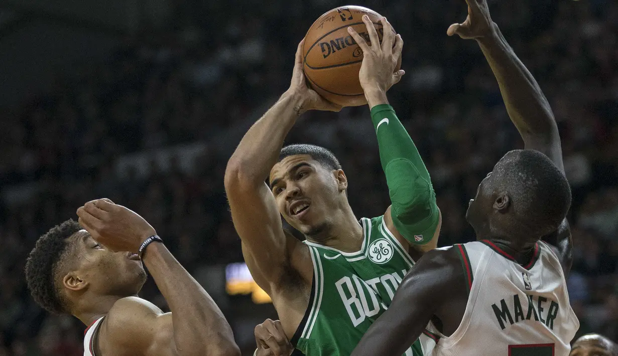 Pemain Boston Celtics, Jayson Tatum (tengah) berusaha melewati adangan dua pemain Bukcs pada laga NBA di basketball game di Milwaukee, (26/10/2017). Boston menang 96-89. (AP/Tom Lynn)