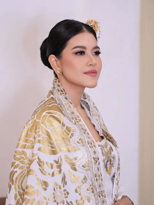 Dalam potret tersebut, istri Bobby Nasution itu memancarkan pesona elegan dibalut dress nuansa emas dari @erasoekamto. [@malvava].