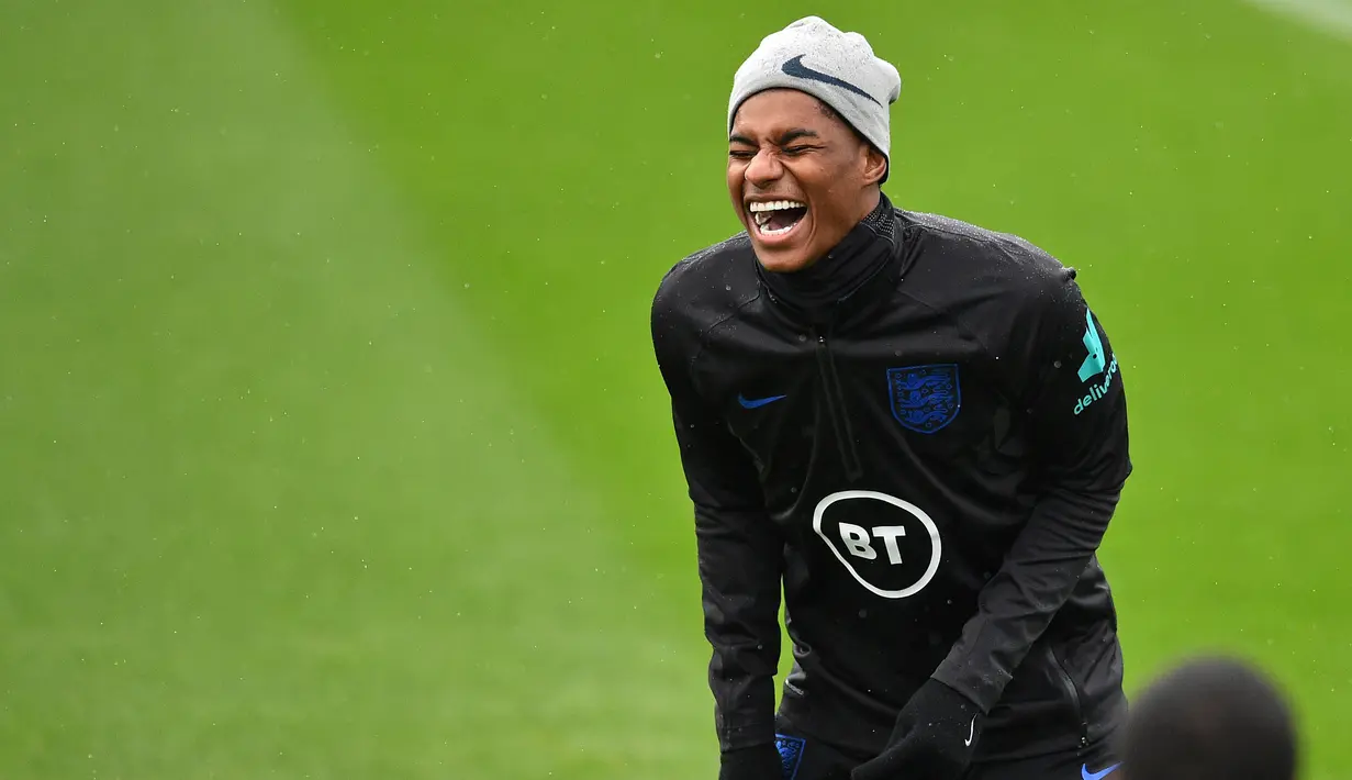 Striker Inggris Marcus Rashford tertawa selama sesi pelatihan tim di Staplewood Campus di southampton, Inggris selatan (9/9/2019). Inggris akan bertanding melawan Kosovo pada grup A Kualifikasi Euro 2020 di Stadion Saint Mary. (AFP Photo/Glyn Kirk)