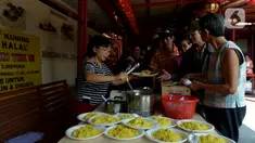 Pengurus Vihara Kim Tek Ie menyiapkan menu makan siang untuk pembeli warung nasi kuning Podjok Halal di Petak Sembilan, Jakarta, Selasa (24/12/2019). Warung Podjok Halal menjual nasi beserta lauk pauk dengan harga Rp 3.000. (merdeka.com/Imam Buhori)