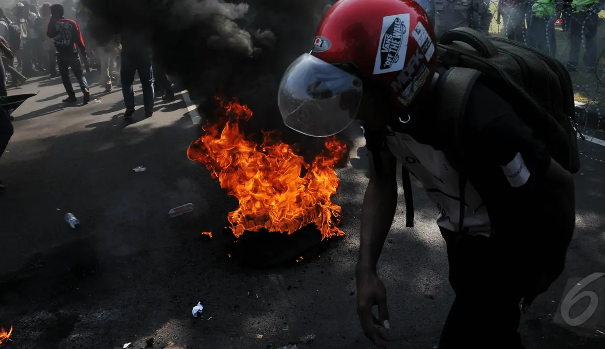 Sebuah ban dibakar saat aksi di depan Istana Presiden, Jakarta, Rabu (20/5/2015). Ribuan mahasiswa menuntut agar Jokowi - JK segera turun. (Liputan6.com/Johan Tallo)