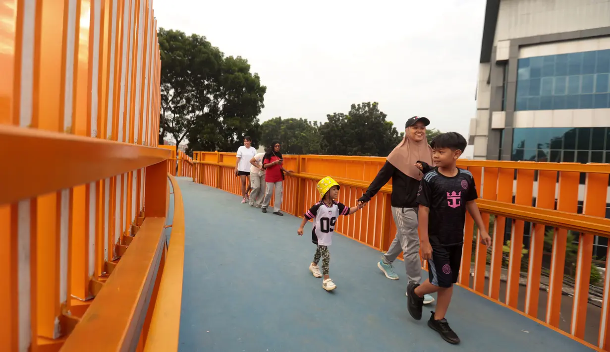 Warga beraktivitas di sekitar Jembatan Penyeberangan Orang (JPO) di Jalan Tegar Beriman, Cibinong, Kabupaten Bogor, Jawa Barat, Minggu (14/6/2026). (Kapanlagi.com/Budy Santoso)