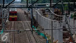 Sebuah Kereta Rel Listrik (KRL) melaju di samping lokasi pembangunan Stasiun Sudirman Baru di Jakarta, Rabu (9/11). Nantinya, saat beroperasi Stasiun Sudirman Baru akan tersambung dengan stasiun bawah tanah milik MRT Jakarta. (Liputan6.com/Faizal Fanani)