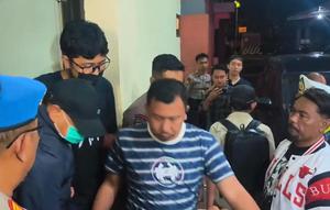 Bupati Sudewo berjaket biru, bertopi hitam dengan memakai masker dinaikan ke mobil dengan kawalan ketat aparat Polres Kudus