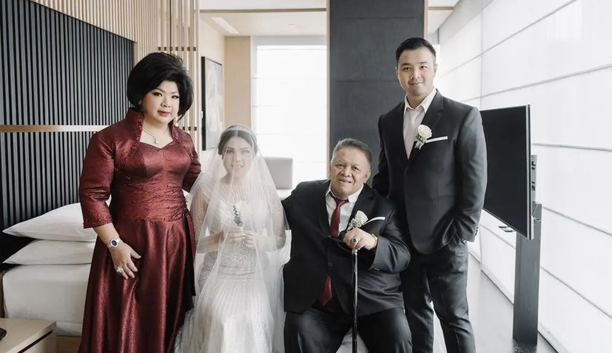 Di hari pernikahan, sang mamah tampil dengan dress merah maroon yang memiliki detail heart neck dan payetan di bagian perut. @tinatoon101