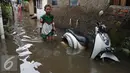 Seorang anak melitasi banjir di kawasan Jatayu, Jakarta, Senin (21/11). Banjir disebabkan tingginya curah hujan dan buruknya saluran air serta meluapnya Kali Pesanggrahan. (Liputan6.com/Gempur M. Surya)