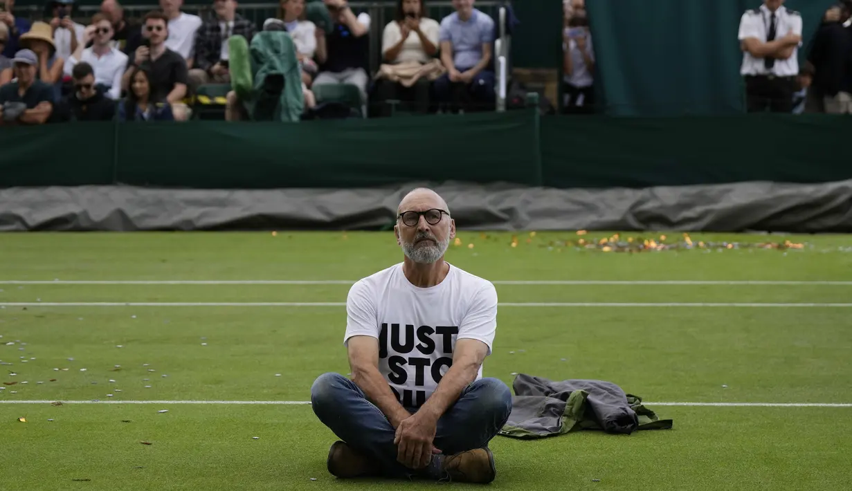 Dua aktivis lingkungan melompat dari tribun penonton di Court 18 dan mengganggu pertandingannya. (AP Photo/Alastair Grant)