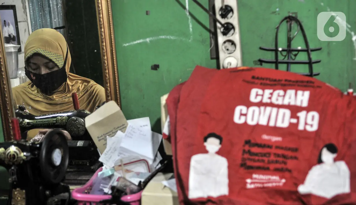 Siti Zahro (44) menyelesaikan pembuatan celemek berbahan tas bansos Covid-19 di industri jahit rumahan KG-Lupe Fashion, Salemba, Jakarta, Senin (16/11/2020). Celemek buatan Siti dijual seharga Rp 50-Rp 150 ribu per buah tergantung ukuran dan kerumitan proses pembuatan. (merdeka.com/Iqbal S. Nugroho)