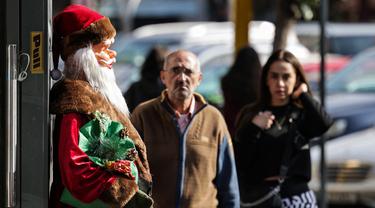 Pemandangan patung Santo Nikolas (Bapa Natal atau Sinterklas) di luar pintu masuk toko mainan di kawasan Burj Hammoud, Beirut, Lebanon, 14 Desember 2021. Semarak jelang Natal yang biasa terjadi di Beirut, tak lagi terasa tahun ini karena krisis keuangan terburuk di Lebanon. (JOSEPH EID/AFP)