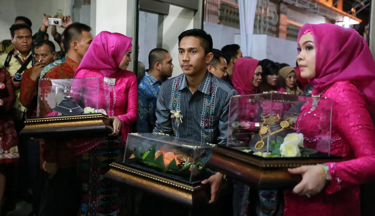 Rombongan yang hadir keluarga besar dari Medan, mengenakan pakaian bernuansa tradisional warna maroon dan peci. Seserahan yang berada dalam kotak dibawa orang yang berseragam abu-abu untuk pria dan merah untuk wanitanya. (Adrian Putra/Bintang.com)