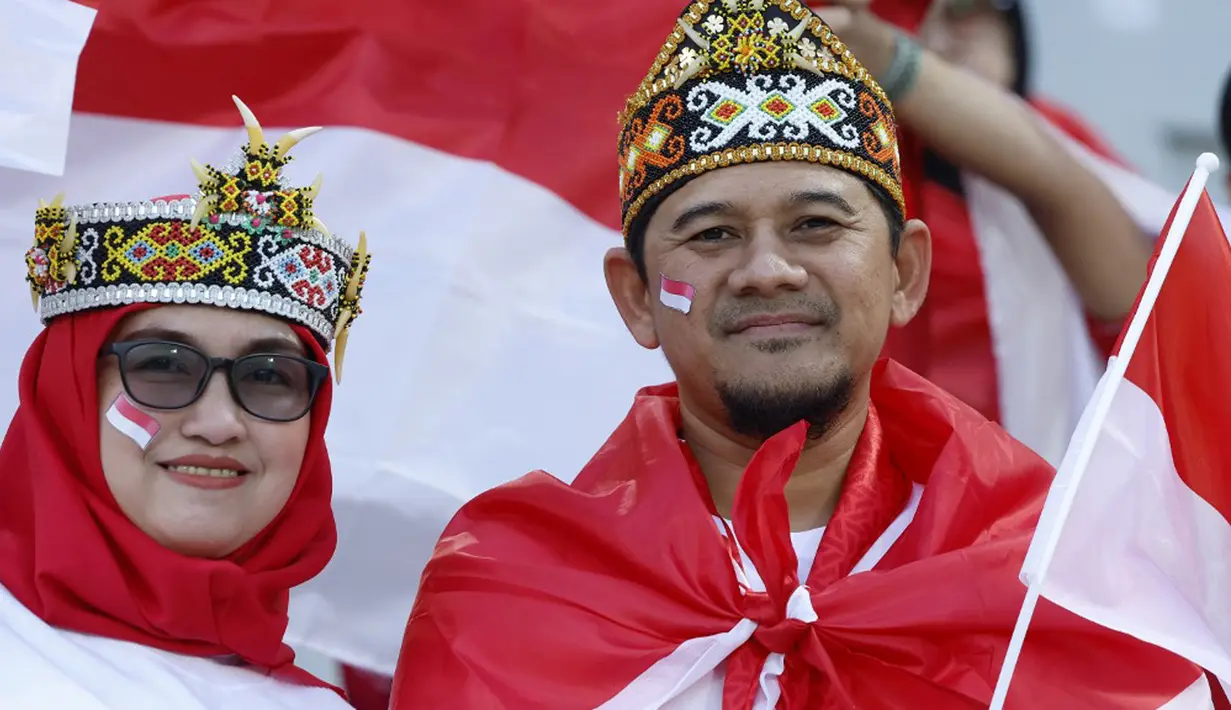 Suporter Timnas Indonesia berpose sebelum dimulainya pertandingan sepak bola Grup D Piala Asia 2023 antara Vietnam dan Indonesia di Stadion Abdullah bin Khalifa, Doha, Qatar, Jumat (19/1/2024). (KARIM JAAFAR/AFP)