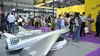 Pengunjung terlihat di samping model drone UAV Flying Eagle H3200 di stan Micro Multi Copter (MMC) selama Drone World Congress (DWC) di Shenzhen pada 21 Mei 2026. (HECTOR RETAMAL/AFP)