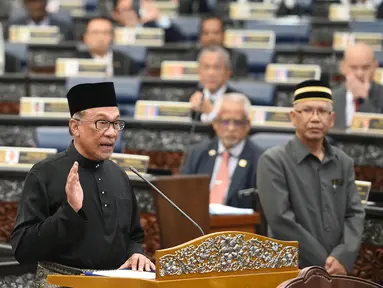 Ketua Partai Keadilan Rakyat Malaysia, Anwar Ibrahim mengucapkan sumpah jabatan dalam upacara pelantikan di Gedung Parlemen, Kuala Lumpur, Senin (15/10). Anwar Ibrahim dilantik sebagai anggota parlemen setelah memenangkan pemilu sela. (MOHD RASFAN/AFP)