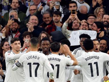 Penyerang Real Madrid, Kylian Mbappe (kanan) merayakan golnya saat laga pekan ke-18 La Liga 2024/2025 melawan Sevilla FC di Stadion Santiago Bernabeu, Madrid, 22 Desember 2024. (OSCAR DEL POZO/AFP)