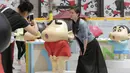 Seorang pengunjung berpose mengikuti ekspresi model Crayon Shinchan saat berfoto di pameran Joy City, Beijing (5/5/2015). Lima puluh model karakter kartun Jepang dalam berbagai pose dan ekspresi dihadirkan dipameran tersebut. (REUTERS/Jason Lee)