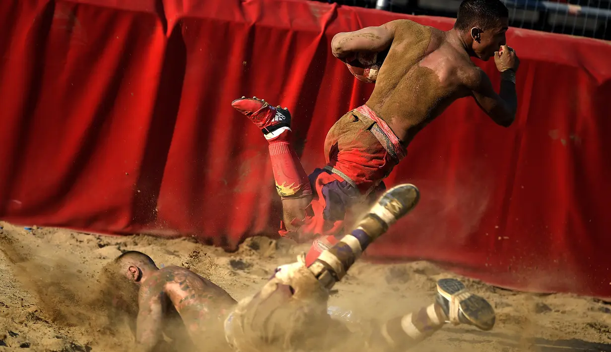 Seorang pemain tersungkur saat pertandingan Calcio Storico Fiorentino di Piazza Santa Croce di Florence, Italia (24/6). Tim ini dibagi menjadi 4 penjaga gawang, 3 gelandang belakang, 5 gelandang tengah, dan 15 penyerang. (AFP Photo/Filippo Monteforte)
