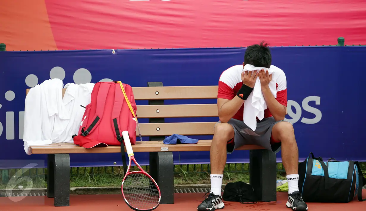 Petenis Indonesia, David Susanto menutup wajahnya usai dikalahkan petenis Thailand Sornbutnark di final tunggal putra SEA Games ke-28 di Kallang Tenis Centre, Singapura, MInggu (14/6/2015). David kalah 6-4, 3-6, 3-6. (Liputan6.com/Helmi Fithriansyah)