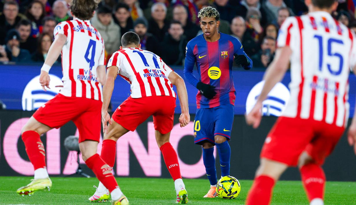 Pemain Barcelona, Lamine Yamal, berusaha melewati pemain Atletico Madrid dalam lanjutan pekan ke-15 La Liga 2025/2026 di Camp Nou, Rabu dini hari WIB, 3 November 2025. (AP Photo/Joan Monfort)
