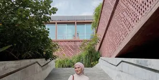 Berada di Bali, Kesha tampil dengan maxi dress floral warna pink yang dipadukan long outer warna serasi dengan kerudungnya. (@kesharatuliu05)