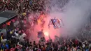 Warga Madrid menyalakan flare saat menyambut konvoi Atletico Madrid merayakan gelar Liga Europa di Madrid, Jumat (18/5/2018). Kota Madrid menjadi merah saat perayaan gelar juara Atletico. (AFP/Javier Soriano)