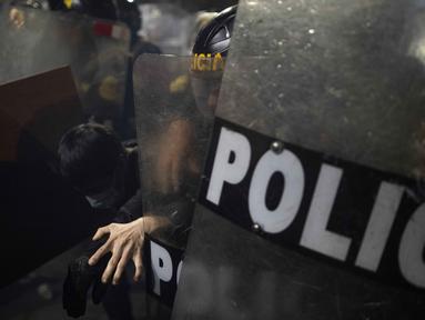 Seorang demonstran bentrok dengan polisi anti huru-hara selama demonstrasi anti pemerintah di Lima, Peru pada 21 September 2025. (ERNESTO BENAVIDES/AFP)