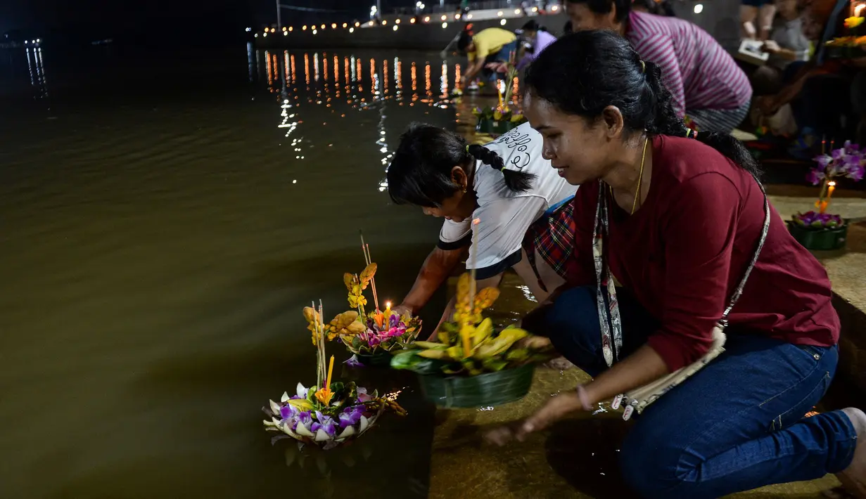 Orang-orang menghanyutkan 'krathong' untuk menandai festival Loy Krathong di sebuah danau di Narathiwat, Thailand,  Senin (11/11/2019). Festival ini biasanya berlangsung pada akhir musim hujan ketika bulan purnama menyala di langit pada November. (Madaree TOHLALA / AFP)