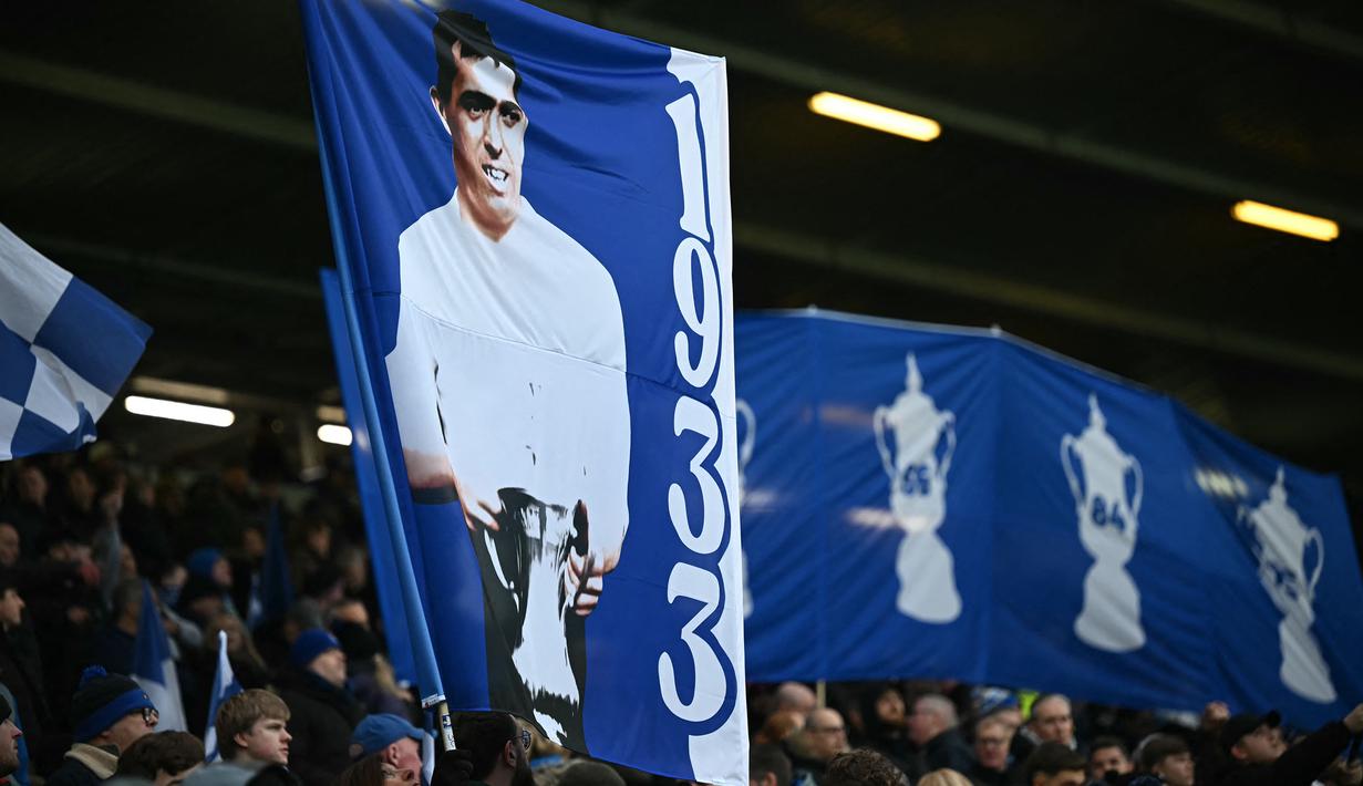 Suporter Everton membentangkan banner bergambar Dixie Dean dalam laga lanjutan Piala FA 2024/2025 melawan Bournemouth di Goodison Park, Liverpool, Inggris, Minggu (09/02/2025) WIB. (AFP/Paul Ellis)