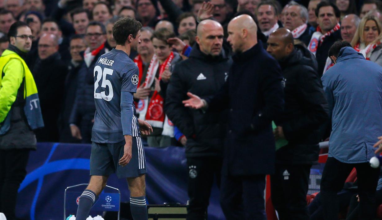 Gelandang Bayern Munchen Thomas Mueller meninggalkan lapangan permainan setelah wasit mengusirnya karena menendang kepala bek Ajax Amsterdam Nicolas Tagliafico dalam laga Grup E Liga Champions di Amsterdam, Belanda, Rabu (12/12). (AP Photo/Peter Dejong)