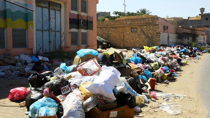 Tumpukan sampah terlihat di sepanjang sisi jalan di Tripoli, ibukota Libya (30/9/2019). Sampah yang berserakan di jalan tersebut menambah cobaan sehari-hari bagi penduduk ibukota yang kehidupannya telah diselingi kekurangan bahan bakar, listrik, dan air. (AFP Photo/Mahmud Turkia)