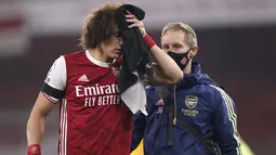 Bek Arsenal, David Luiz memegang handuk pada luka di kepalanya setelah terlibat benturan dengan Raul Jimenez dari Wolverhampton Wanderers pada pekan kesepuluh Liga Inggris di Emirates Stadium, London, Minggu (29/11/2020). Arsenal takluk 1-2 dari Wolverhampton Wanderers. (John Walton/Pool via AP)