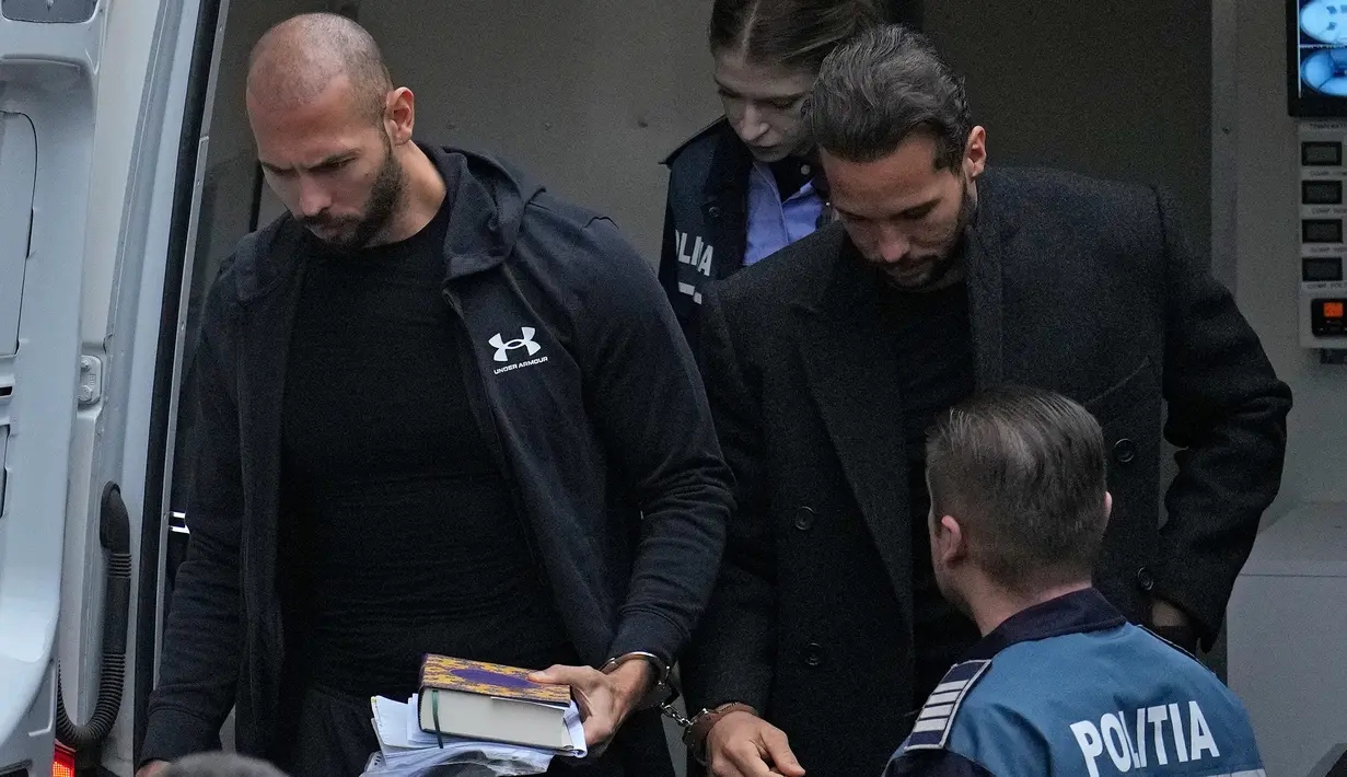 Andrew Tate (kiri) dan saudaranya Tristan (kanan) dibawa oleh polisi ke Pengadilan Banding di Bukares, Rumania, Selasa (10/1/2023). Tate, warga Inggris-AS berusia 36 tahun, ditahan otoritas Rumania atas dugaan perdagangan manusia, pemerkosaan, dan membentuk kelompok kejahatan. (AP Photo/Vadim Ghirda)