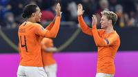 Bek Belanda, Virgil Van Dijk, merayakan gol bersama Frenkie De Jong pada laga UEFA Nations League di Veltins Arena, Gelsenkirchen, Senin (19/11/2018). Kedua tim bermain imbang 2-2. (AP/Martin Meissner)