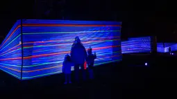 Pengunjung melihat instalasi seni berjudul 'Horizontal Interference' oleh seniman Katarzyna Malejka dan Joachim Slugocki selama Festival Cahaya Lumiere Durham di Inggris utara, 15 November 2017. (OLI SCARFF/AFP)