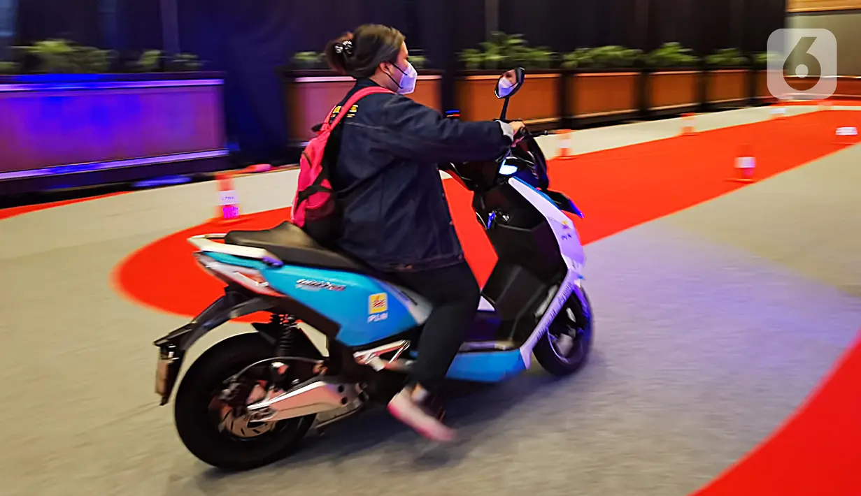 Seorang perempuan menjajaln motor listrik dalam Indonesia Electric Motor Show (IEMS) 2022 di Jakarta Convention Center, Jakarta, Kamis (29/9/2022). Dengan tema ‘Strengthening Autonomus Ecosystem’, ada sekitar 50 peserta pameran yang mengikuti pameran ini. (Liputan6.com/Johan Tallo)