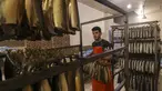 Seorang pemuda Palestina bekerja di fasilitas pengasapan makarel saat ikan itu akan dijual jelang liburan Idul Fitri di Rafah di Jalur Gaza selatan (26/4/2022). Ikan asap makarel menjadi salah satu menu hidangan buka puasa dan Idul Fitri terfavorit bagi warga Gaza selama Ramadhan.(AFP/Said Khatib)