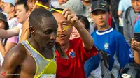 Jokowi berusaha mengejar pelari Kenya, Stephen Kipkemei Tum, untuk mengalungkan kartu peringkat saat menyentuh garis finish dalam ajang lomba lari, Mandiri Jakarta Marathon 2013, di kawasan Monas, Jakarta, Minggu 27 Oktober lalu. (Antara/Ismar Patrizki/is