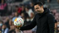 Ekspresi kekecewaan pelatih Xavi Hernandez terlihat jelas ketika Barcelona dikalahkan Cadiz dengan skor 0-1 pada laga pekan ke-32 Liga Spanyol 2021/2022 di Camp Nou, Selasa (19/04/2022) dini hari WIB. (AFP/Lluis Gene)