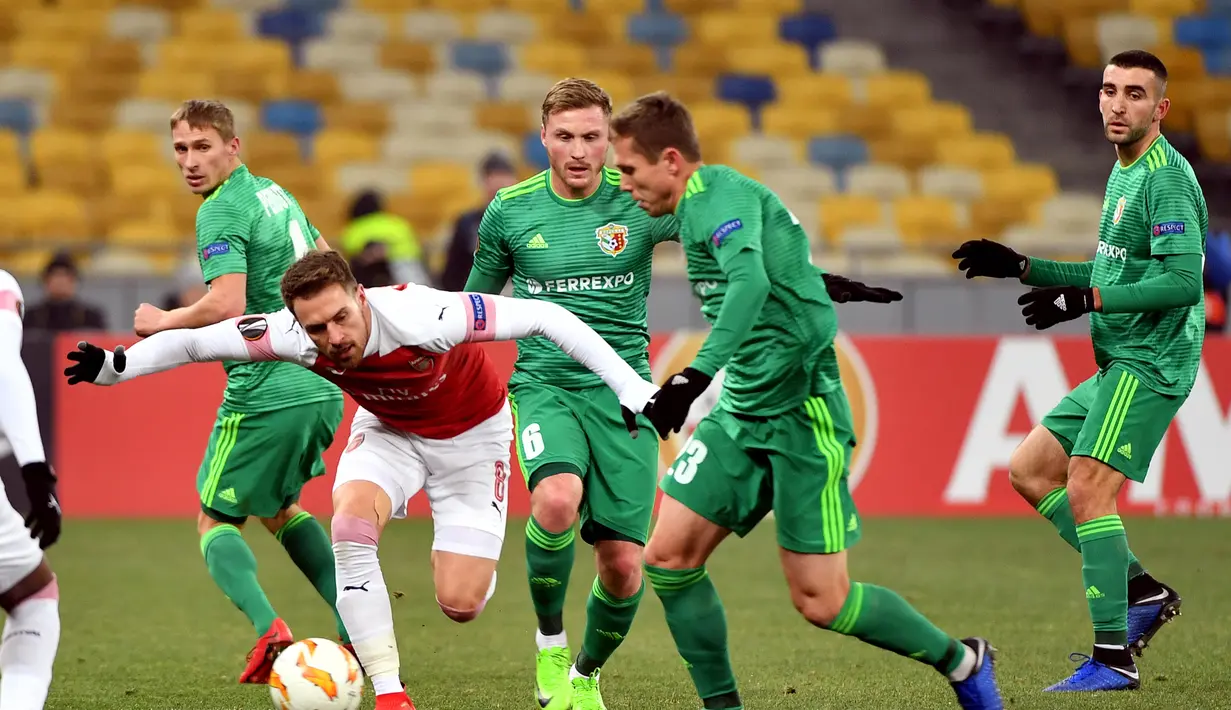 Gelandang Arsenal, Aaron Ramsey beraksi melewati pemain Vorskla pada laga lanjutan Grup E Liga Europa yang berlangsung stadion NSK Olimpiyskiy, Kyiv, Jumat (30/11). Arsenal menang atas Vorskla 3-0. (AFP/Sergei Supinsky)