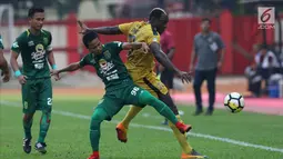 Pemain Bhayangkara FC, Herman Dzumafu (kanan) berebut bola dengan pemain Persebaya pada lanjutan Go-Jek Liga 1 Indonesia bersama Bukalapak di Lapangan PTIK, Jakarta, Rabu (11/7). Babak pertama, Bhayangkara FC unggul 2-1. (Liputan6.com/Helmi Fthriansyah)