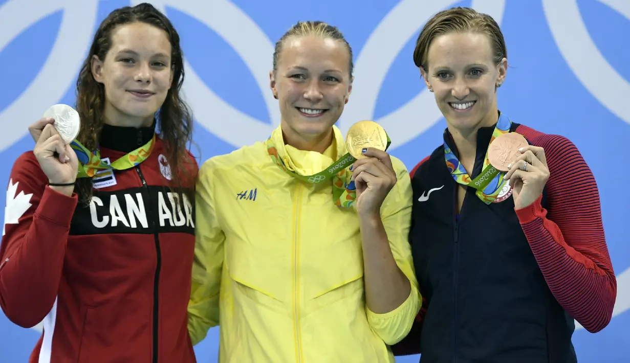 Perenang Swedia Sarah Sjostrom (tengah) berpose dengan perenang Kanada, Penny Oleksiak yang memenangkan perak dan Dana Vollmer dari Amerika Serikat yang memenangkan perunggu dalam cabang renang putri di Olimpiade 2016, Minggu (7/8). (Christophe SIMON/AFP)
