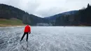 Seorang wisatawan asyik bermain ice skating atau seluncur es di atas sungai Doubs yang membeku di perbatasan Perancis Les Brenets, Swiss, Senin (2/1). Sungai ini menjadi objek wisata es yang diminati warga. (REUTERS/Denis Balibouse)
